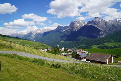 Scenic view of field by mountains against sky