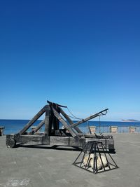 Lifeguard hut on beach against clear blue sky