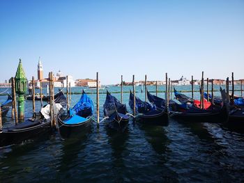 Boats moored in canal against clear sky