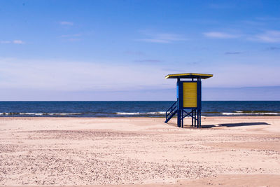 Lifeguard hut on beach against sky