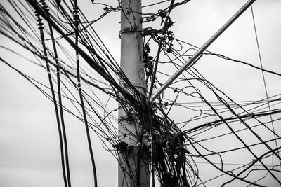 Tangle of wires and cables on a pole against the clear sky. salvador, bahia, brazil.