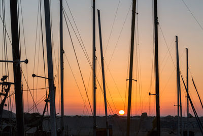 Silhouette of poles against sky during sunset