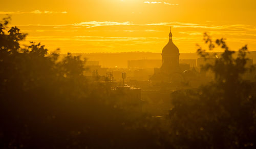 Silhouette of buildings against sky during sunset