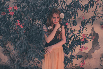 Portrait of woman standing against plants