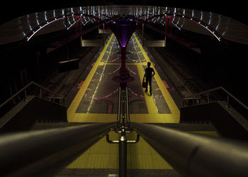 High angle view of man walking on illuminated station platform