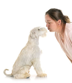 Close-up of woman with dog against white background