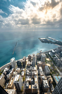 High angle view of buildings by sea against sky