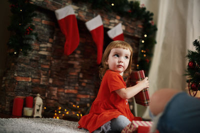 Portrait of young woman holding christmas tree