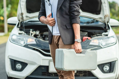 Low section of man standing in car