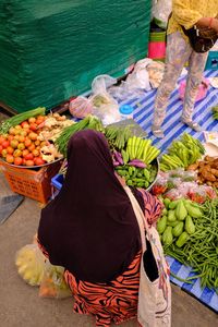 High angle view of woman buying vegetables