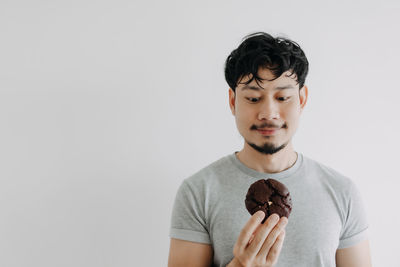 Portrait of young man standing against white background