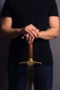 Midsection of man holding paper against black background