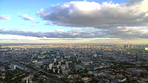 High angle view of city buildings against cloudy sky