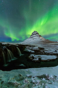 Scenic view of snowcapped mountains against sky at night