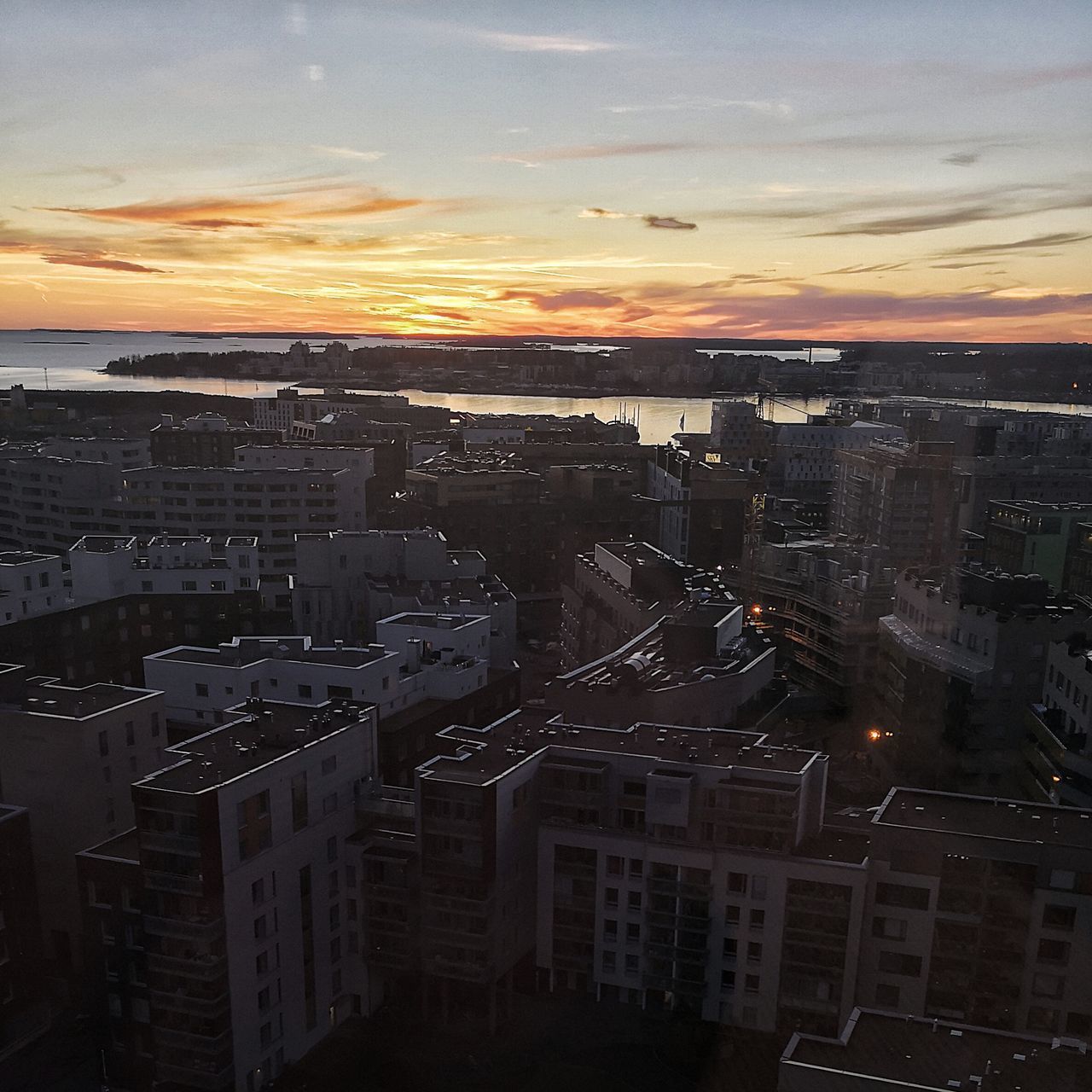 HIGH ANGLE VIEW OF ILLUMINATED CITY DURING SUNSET