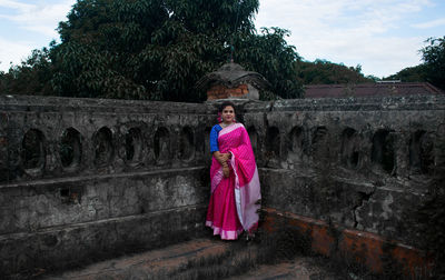 Rear view of woman standing against wall