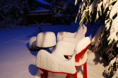 Rear view of woman relaxing on snow covered tree