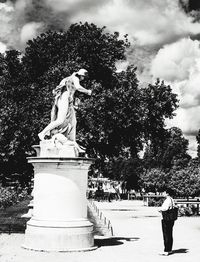 Statue of woman against cloudy sky