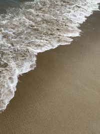 High angle view of waves rushing towards shore