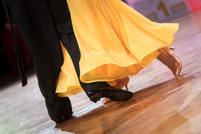 Low section of couple dancing on hardwood floor