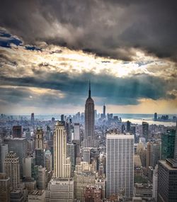 Modern buildings in city against cloudy sky