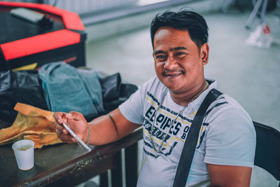 Portrait of smiling man standing by car