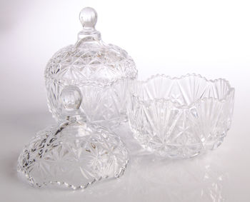 Close-up of glass containers with lid on white background