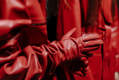 Close up fashion details of brown orange leather jacket and gloves, stylish modern clothing details