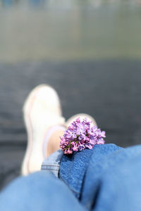 Lilac bunch on blue jeans and white clean sneakers. young and freedom atmosphere
