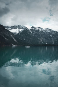 Scenic view of lake and snowcapped mountains against sky