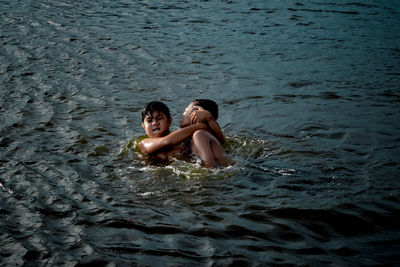 Full length portrait of mother and woman at sea shore