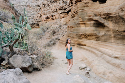 Rear view of woman standing on rock