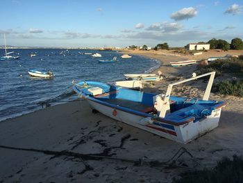Boat moored on beach against sky
