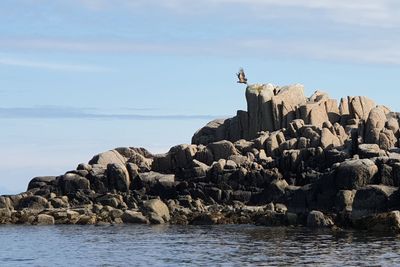 Rock formations on beach against sky