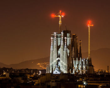 Illuminated sagrada familia in barcelona against sky at night