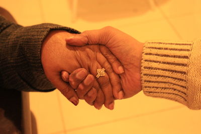 Midsection of couple holding hands