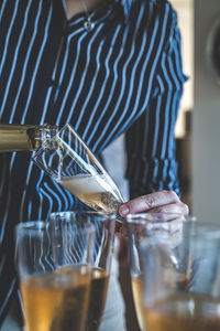 Midsection of woman holding wineglass
