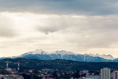  city of sochi overlooking the houses and the snow capped mountain in the background