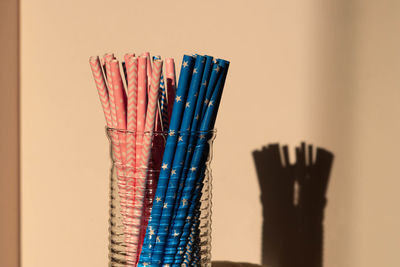 Close-up of multi colored pencils on table against wall