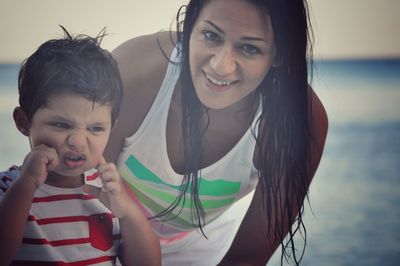 Portrait of happy mother with daughter standing outdoors