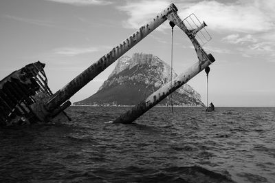 Shipwreck in sea against sky