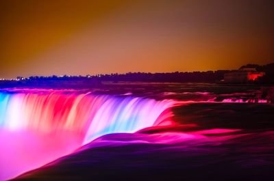 Scenic view of waterfall against sky at night