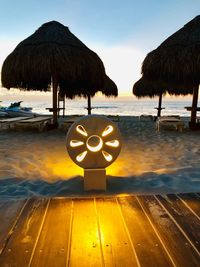 Information sign on beach against sky during sunset
