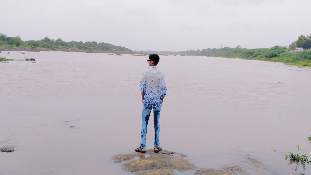 rear view, one person, real people, full length, standing, casual clothing, water, sea, day, nature, men, beach, sky, leisure activity, sand, outdoors, beauty in nature, lifestyles, scenics, people