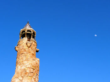 Low angle view of bell tower against blue sky