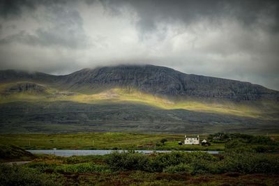 Scenic view of mountains against cloudy sky