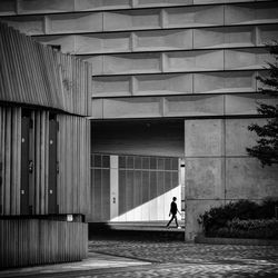 People walking on footpath against building in city