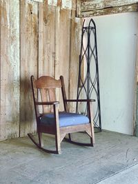 Empty chair on table against wall