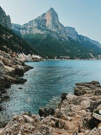 Scenic view of sea and mountains against sky