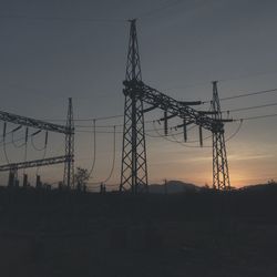 Electricity pylon against sky during sunset